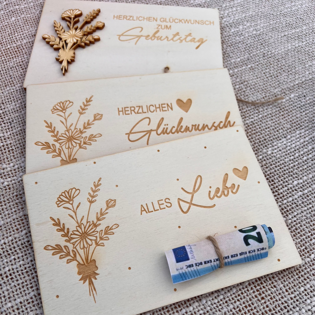 Drei gravierte Holz-Geschenkkarten mit floralen Motiven und Sprüchen wie „Herzlichen Glückwunsch“ und „Alles Liebe“, ideal als kreative Geldgeschenke
